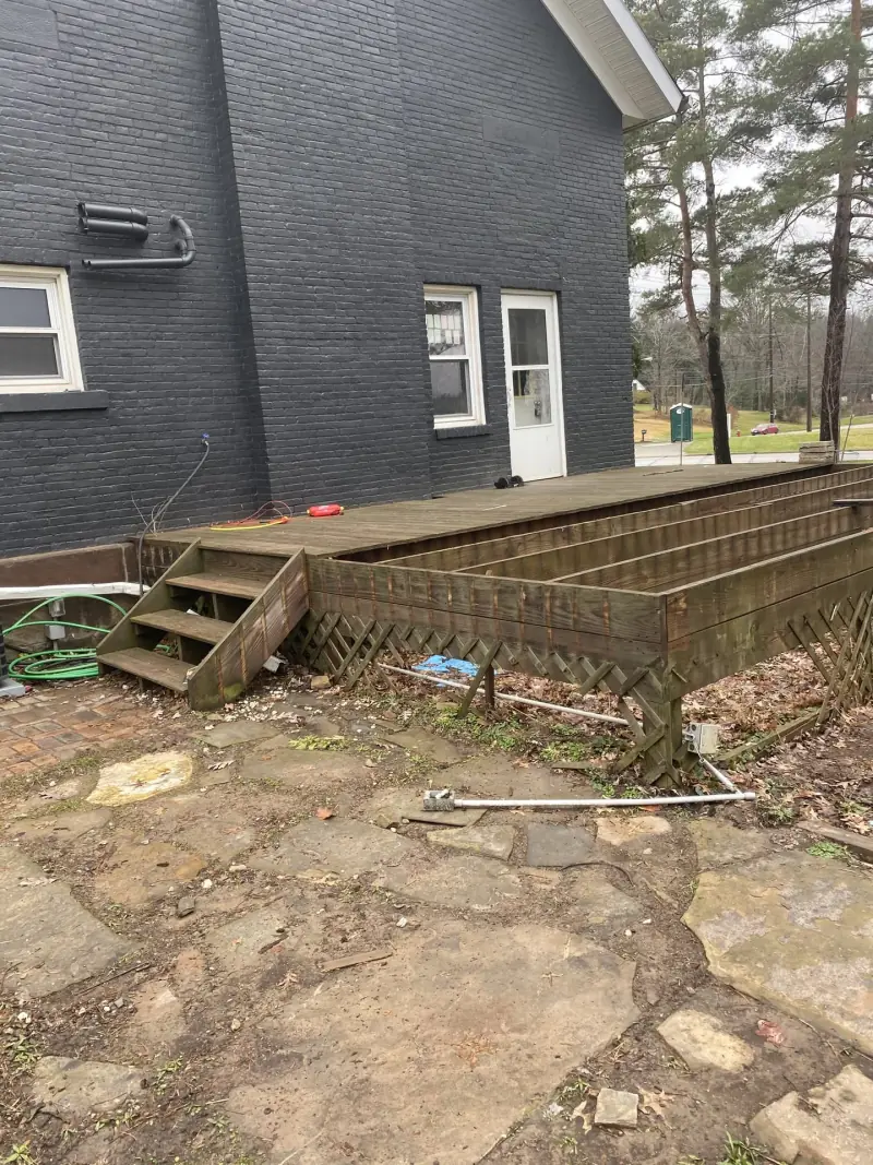 Existing wood deck along the rear of a brick home